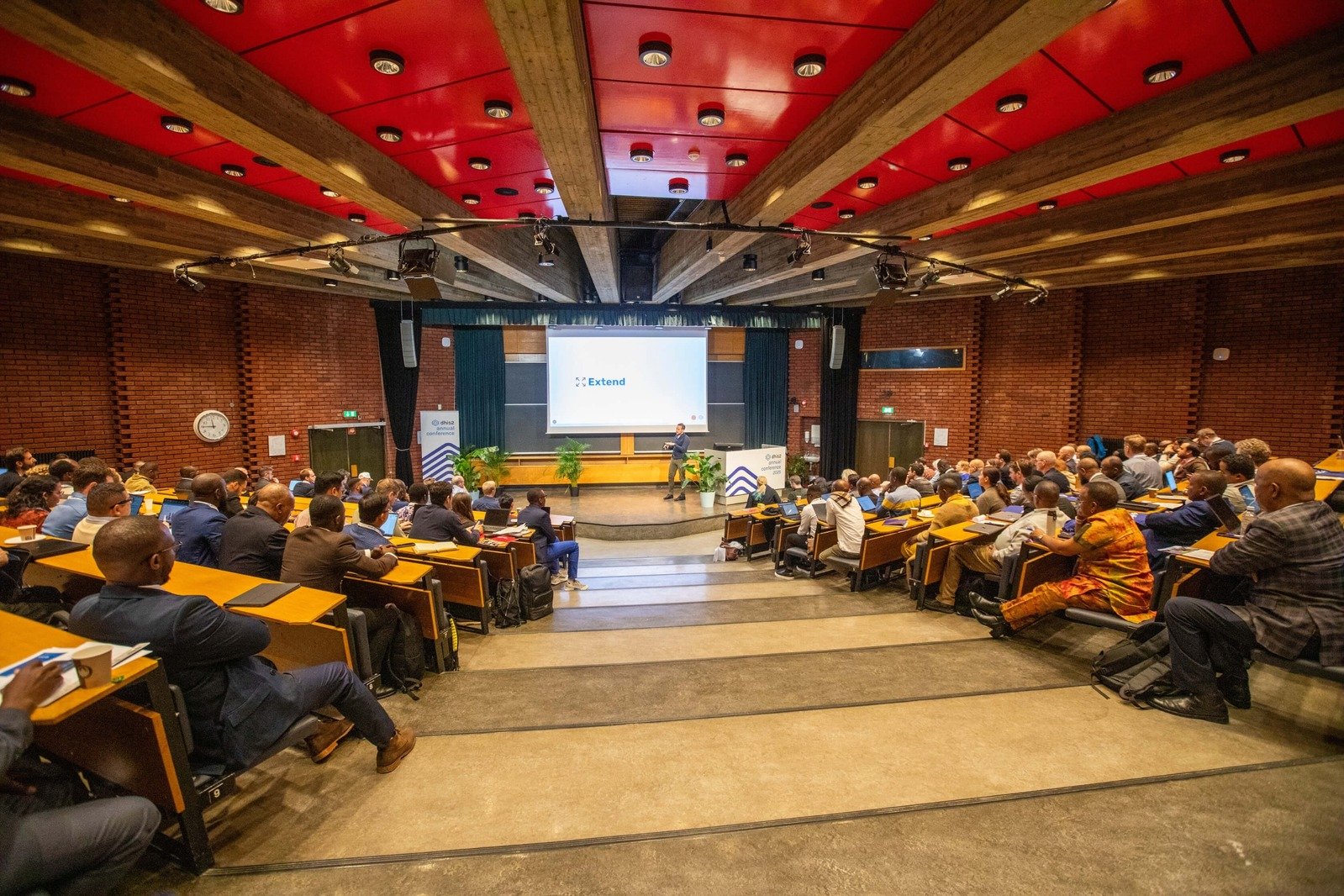 DHIS2 Annual Conference presentation with speaker Austin Mcgee on stage.