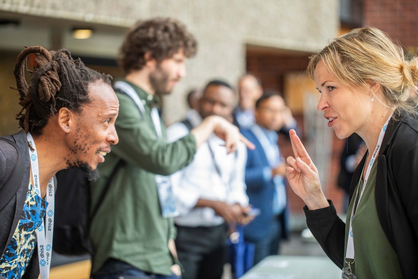 DHIS2 annual conference attendees networking and having a discussion.