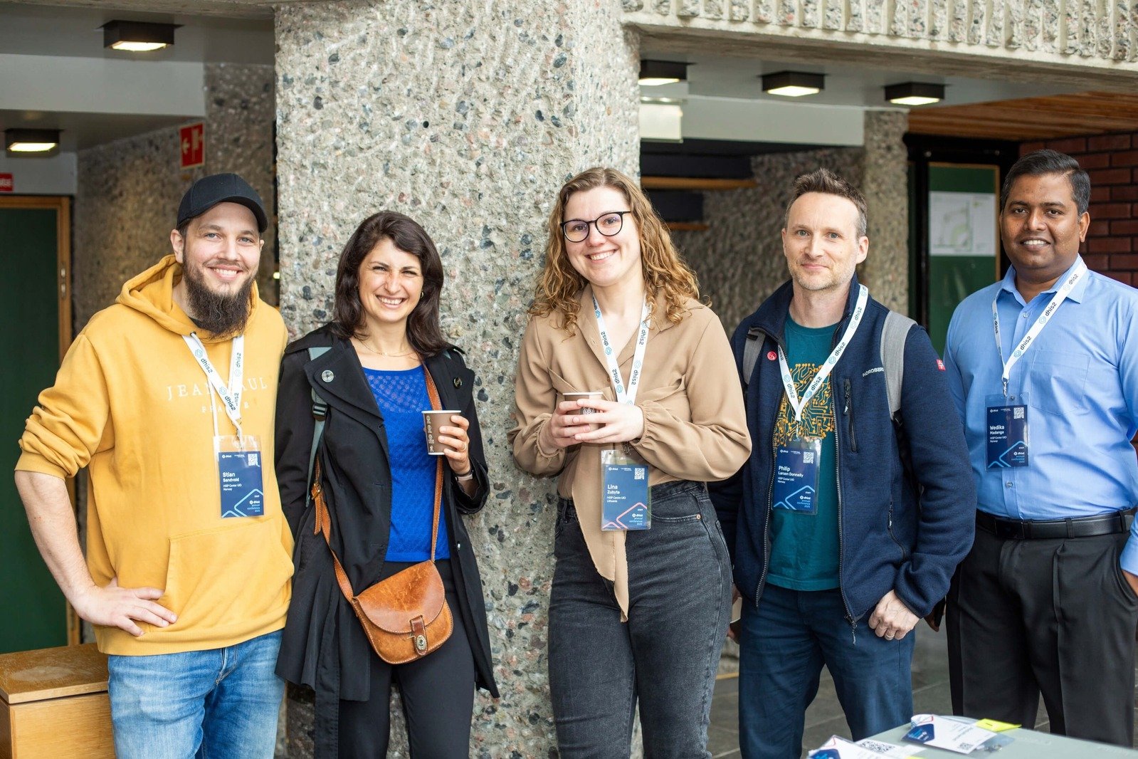 Five attendees networking and smiling during a coffee break at the DHIS2 Annual Conference.